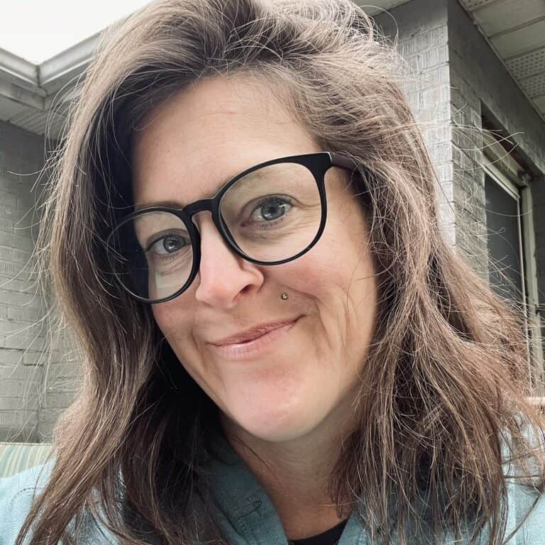 Professional woman with glasses smiling outdoors at Prestige Digital, showcasing digital marketing solutions and online branding services.